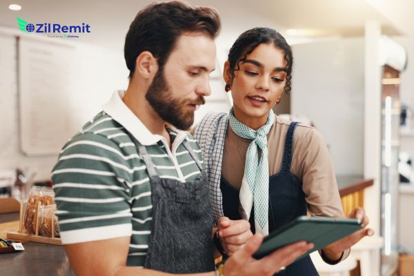 Business owners reviewing cash flow on tablet